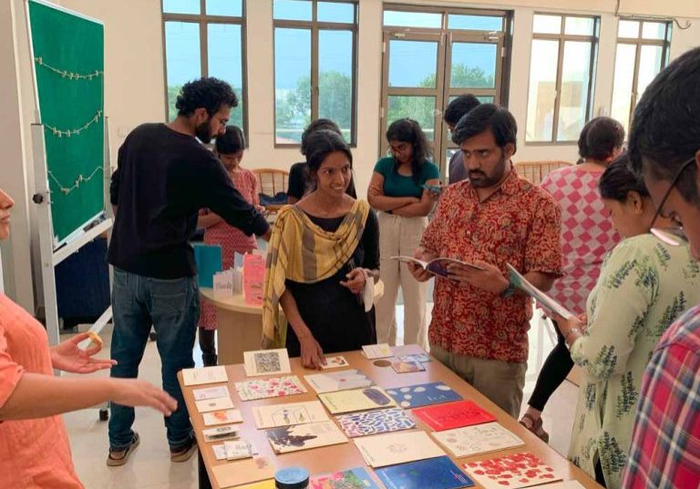 Audience engaging with zine display at TIFR Hyd